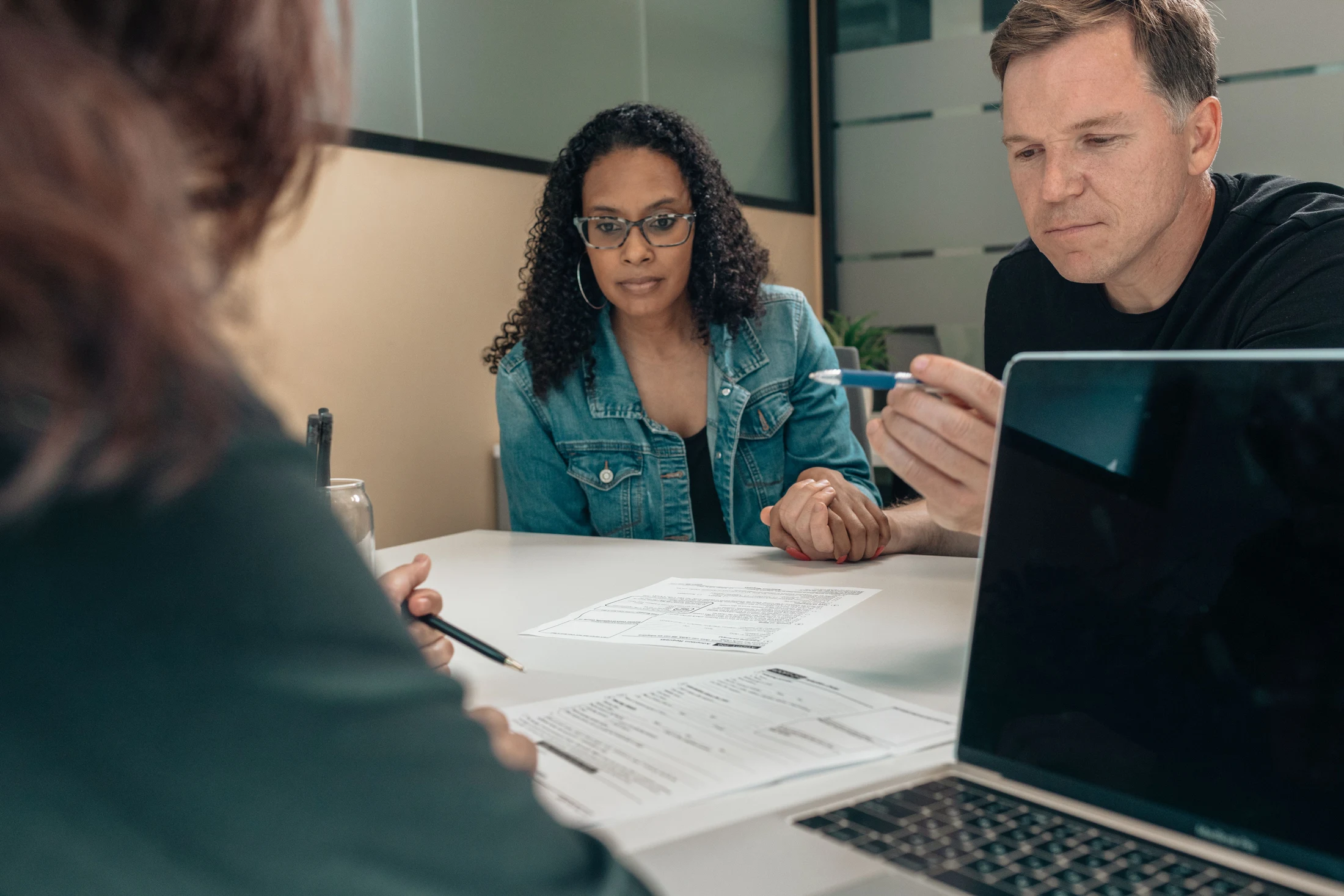 People listening and reviewing documents around a table
